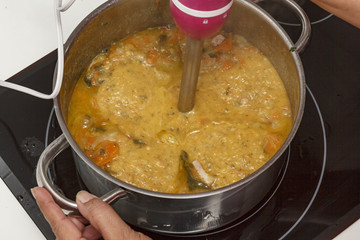 Mamá preparando puré de verdura en casa.