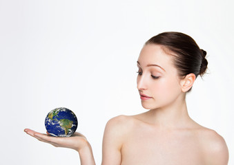 Beautiful woman holding earth globe on her arm