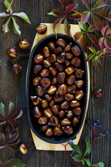 Roasted chestnuts on an old board. Selective focus.