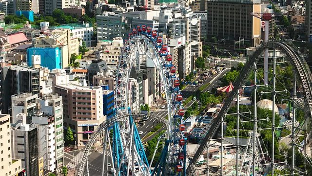 Tokyo - May 2016: Aerial view of city with ferris wheel, amusement park and traffic. 4K resolution time lapse zoom out.