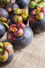 Mangosteen and cross section showing the thick purple skin and w