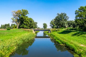 Fototapeta na wymiar Countryside landscape railroad steel bridge over water canal