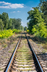 Straight railroad track on Slovak countryside, late summer