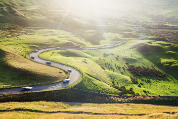 Scenic Serpentine Road with Cars in Golden Sunset Light