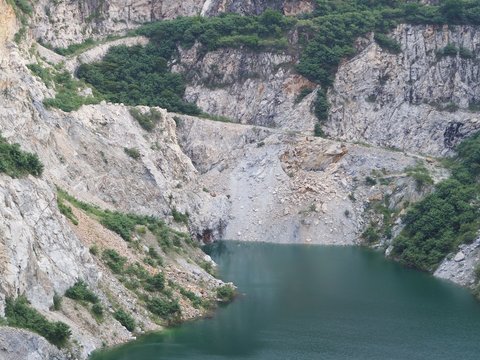 Granite open pit mining with blue green pond