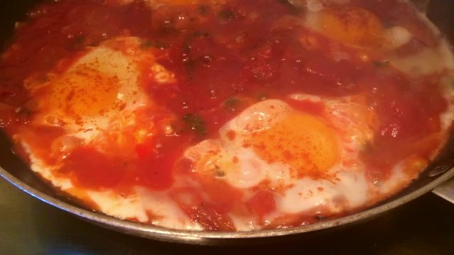 Shakshouka or shakshuka is a North African Jewish origin dish of eggs poached in a sauce of tomatoes, chili peppers, and onions, often spiced with cumin.