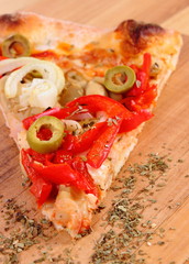 Slice of vegetarian pizza and seasoning on wooden surface