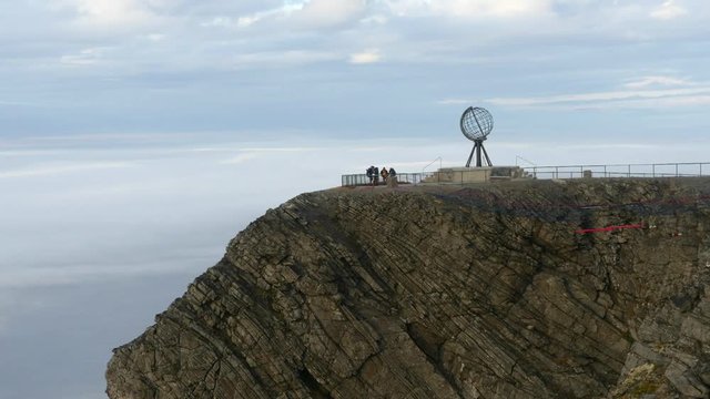 Time-lapse of people at north cape monument, in front of moving fog in the barent sea, in Nordkapp, Finnmark, Norway
