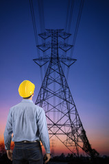 Engineer holding yellow helmet with Transmission tower.