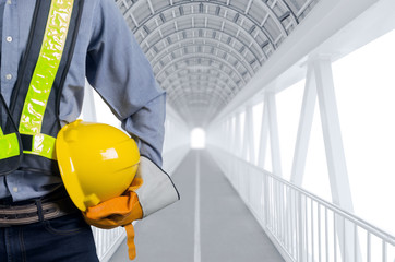 Engineer holding yellow helmets