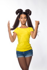 Emotional young brunette girl with long hair in yellow shirt on a white background
