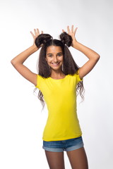 Emotional young brunette girl with long hair in yellow shirt on a white background