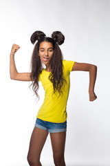 Emotional young brunette girl with long hair in yellow shirt on a white background