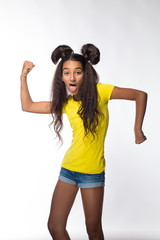 Emotional young brunette girl with long hair in yellow shirt on a white background