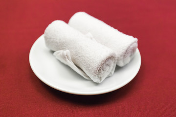 Fototapeta na wymiar Two pieces of white rolled napkin on white dish