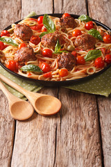 Homemade spaghetti with meatballs and tomato sauce closeup on a plate. vertical

