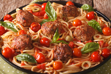 Italian spaghetti with meatballs, olives, basil and tomato sauce closeup. horizontal
