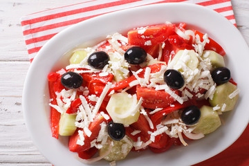 Shopska salad from fresh vegetables with feta cheese close-up. Horizontal top view
