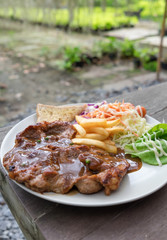 Pork steak tasty with salad vegetarian on wood table