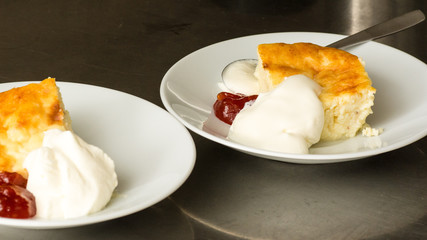 Two pieces of desserts - cheescake with cream