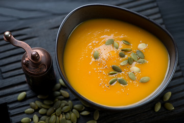 Pumpkin cream-soup topped with pumpkin seeds, close-up