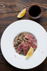 Top view of roasted tuna steak served with buckwheat noodles