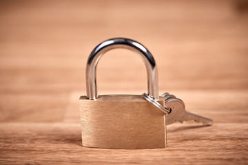 Padlock and keys on a brown wooden table