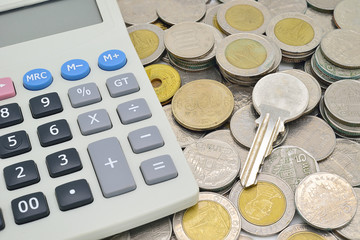 calculator, key and stack of coins