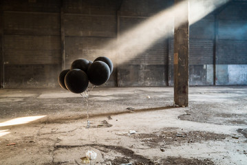 Black balloon with sunlight and shadow in a deserted godown