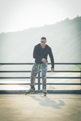 young man with inline skates ride in summer park seafront outdoor rollerskater