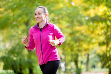 Portrait of an attractive smiling woman jogging in the fall time. Concept photo