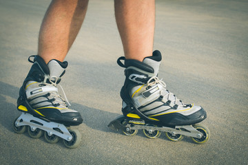 Rollerskater inline in action. Male legs shod in roller skates ride along the promenade