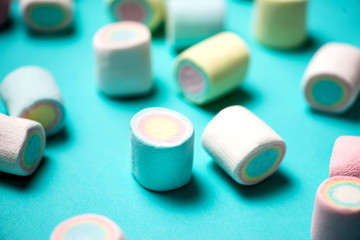 Top view of pastel colored marshmallow on a blue background. Min