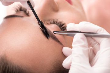 Obraz premium Skillful cosmetician pulling out brows
