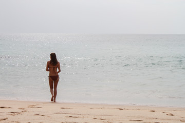 Fototapeta na wymiar womman walking through the beach. Vacations on shore