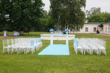 Blue path to the altar lies between white chairs for guests