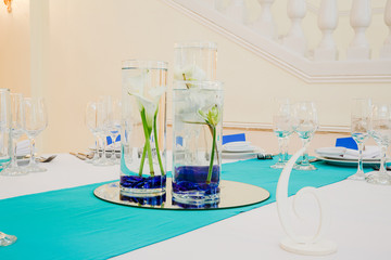 Table decor. White lily calla put in a glass vase full of water