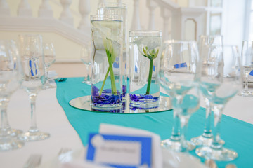 Calla put in glass vases with blue stones stands in the middle o