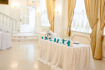 White table decorated with blue candles stand behind a big brigh