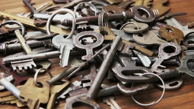 Heap of old keys to doors on wooden background
