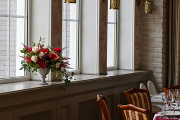 Interior decor. A bouquet of roses in the old-fashioned vase sta