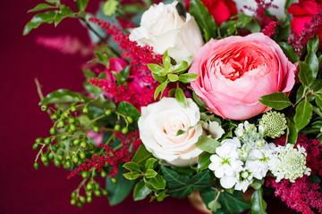 A bouquet of tender pink and white roses on a red background