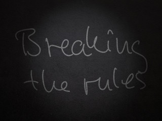 Handwritten saying "Breaking the rules" on a wall