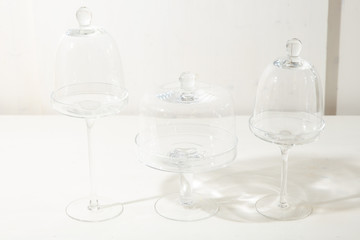 Round plates on stems under covers stand on a white table