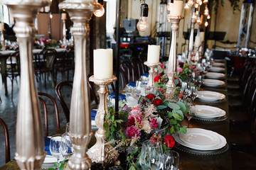 High golden candleholders stand on an aristocratic served dinner