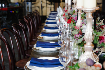 A view on a aristocratic served dinner table with blue serviette