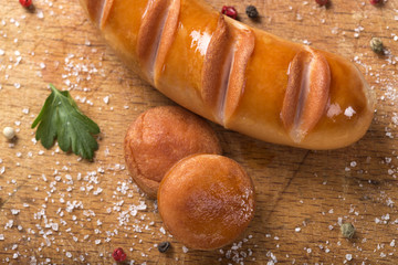 Fried Polish sausage and two slices on an wooden board