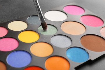 Naklejka premium Colorful eye shadow palette with brush, closeup