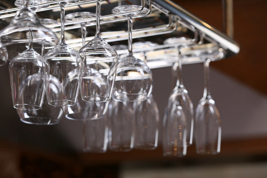 Wine glasses hanging in holder in bar