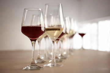 Glasses with red and white wine on table in restaurant